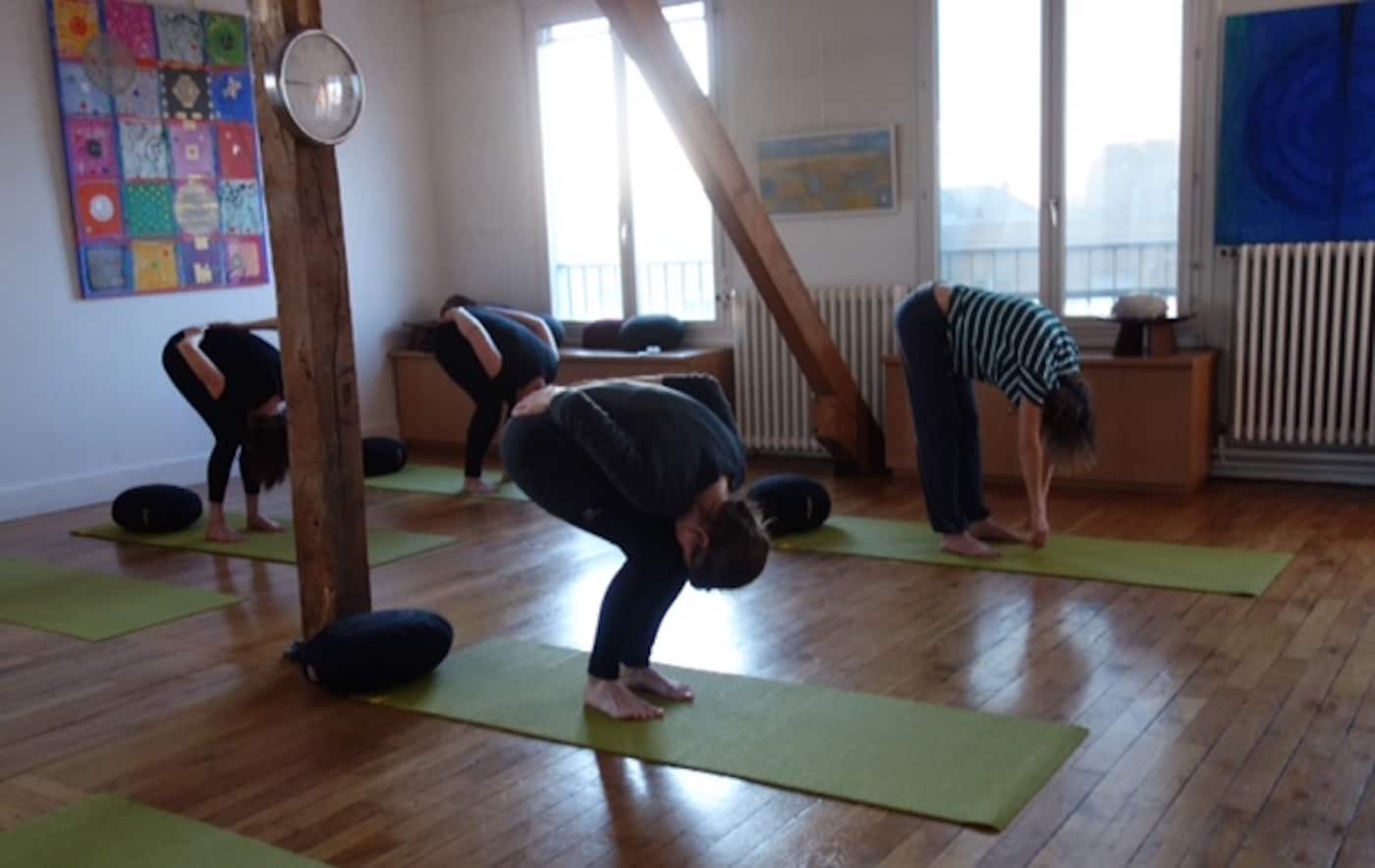 groupe en pleine séance collective de yoga en plein air à paris